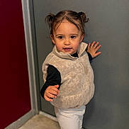 Leynah participe au concours pour gagner de l'argent avec cette photo : toddler, child, door, vest, pigtails, sneakers, white_pants, black_long_sleeves, floor, hallway, playful, standing, indoor, person, clothing, pose, hair, young_child, cute, smile