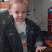 Kenzio participe au concours pour gagner de l'argent avec cette photo : toddler, child, denim_jacket, smile, indoor, toy, playroom, furniture, cute, person, young_child, hair, face, clothing, shirt, hand, expression, home, background, shelf