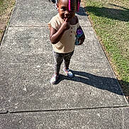Hazeleigh is registered to the contest to win money with this photo: toddler, child, sidewalk, outdoor, sunlight, shadow, grass, beads, hair, pink, clothing, sippy_cup, playful, person, footwear, patterned_pants, short_sleeve_shirt, cute, smiling, standing