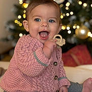 Kiara a rejoint le concours — aidez-le/la à gagner de superbes lots ! baby, blue_eyes, bokeh_lights, cardigan, child, christmas_tree, cozy, happy, holiday, indoor, infant, knitted_cardigan, open_mouth, ornament, pink_sweater, portrait, sitting, smile, teether, toy