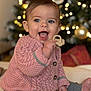 baby, blue_eyes, bokeh_lights, cardigan, child, christmas_tree, cozy, happy, holiday, indoor, infant, knitted_cardigan, open_mouth, ornament, pink_sweater, portrait, sitting, smile, teether, toy