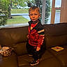 Easton joined the competition — help win amazing prizes! child, boy, toddler, portrait, standing, couch, leather, indoors, living_room, red_jacket, black_clothing, sneakers, short_hair, facial_expression, pouting, window, porch, outdoors, rainy_weather, book