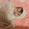 baby, infant, child, pacifier, hood, blanket, pink, bed, sleeping, lying_down, portrait, face, brown_hair, cozy, indoors, nursery, textile, soft, candid, home