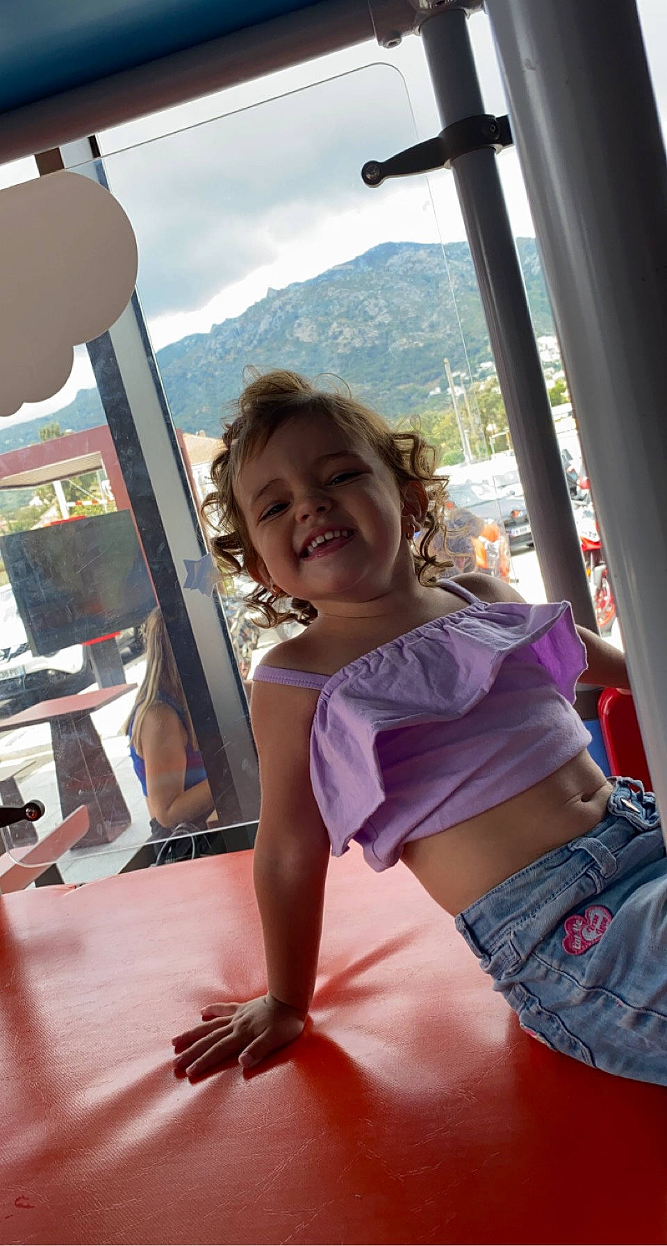 Lily participe au concours pour gagner de l'argent avec cette photo : child, fun, hairstyle, happy, human_leg, joy, leisure, mountain, person, public_space, recreation, shorts, sitting, sky, smile, summer, t_shirt, thigh, toddler, travel