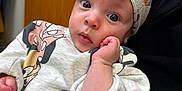 Alora is registered to the contest to win money with this photo: baby, infant, headband, mickey_mouse, minnie_mouse, clothing, hand, person, indoor, door, wall, electrical_outlet, cute, portrait, holding, expression, face, eyes, sleeve, skin