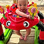 baby, child, colorful, deck, feet, flower, green, happy, infant, outdoor, person, plastic, playful, red, smiling, summer, tongue_out, toy, walker, yellow