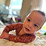 Alora is registered to the contest to win money with this photo: baby, blanket, child, closeup, clothing, curious, cute, expression, eyes, face, hand, indoors, infant, long_sleeve, lying_down, mouth, patterned, portrait, quilt, soft_light