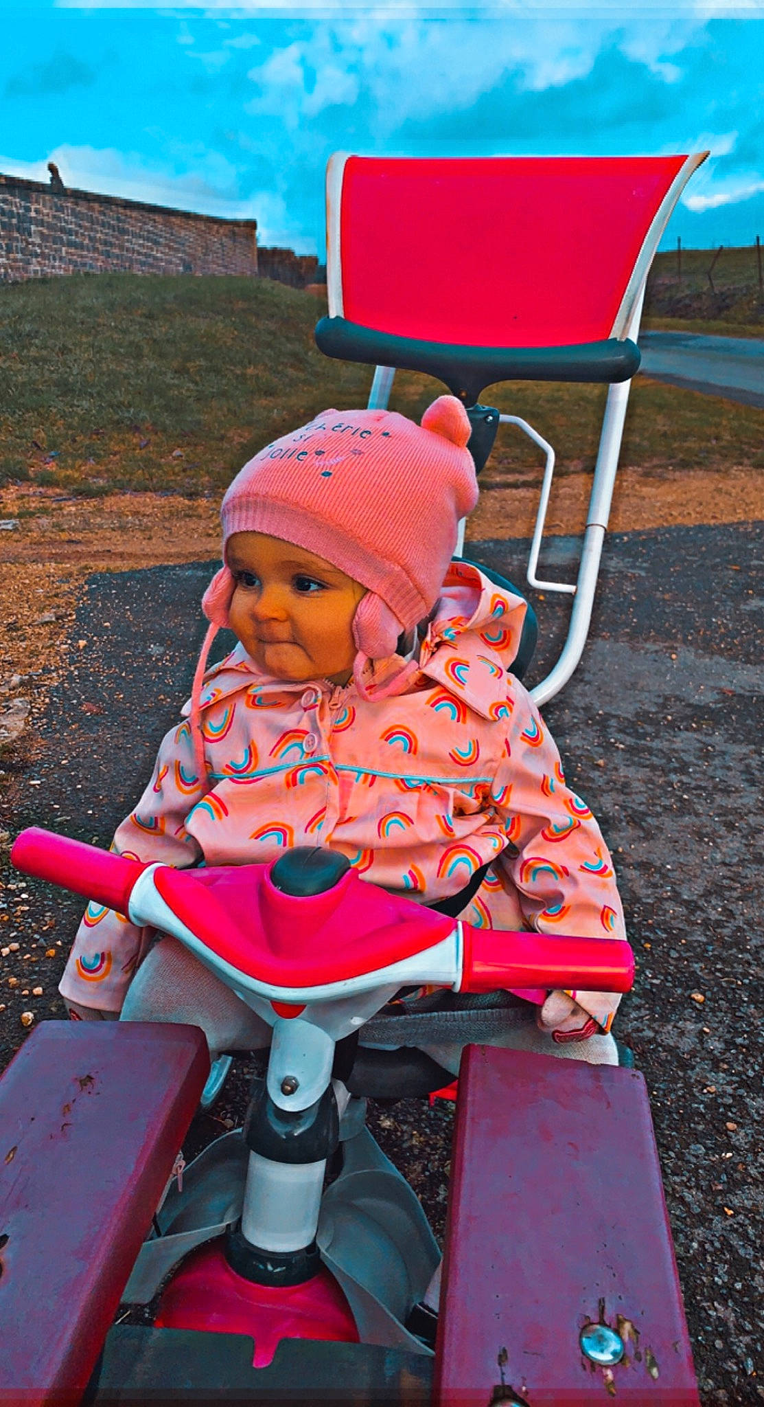 Jennah participe au concours pour gagner de l'argent avec cette photo : baby, baby_carriage, baby_products, baby_toddler_clothing, chair, child, fun, grass, headwear, leisure, magenta, outdoor_furniture, person, personal_protective_equipment, recreation, red, sitting, sky, sunglasses, toddler