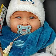 Mylann a rejoint le concours — aidez-le/la à gagner de superbes lots ! baby, pacifier, hat, blue_eyes, scarf, car_seat, toy, beads, warm_clothing, closeup, child, cute, smiling_eyes, infant, winter_wear, plush, accessory, face, portrait, bundle