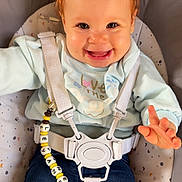 Leyane a rejoint le concours — aidez-le/la à gagner de superbes lots ! baby, child, smiling, happy, face, hair, pony_tail, clothing, sweater, jeans, baby_seat, safety_harness, pacifier, pacifier_clip, indoor, cute, comfort, infant, person, seated