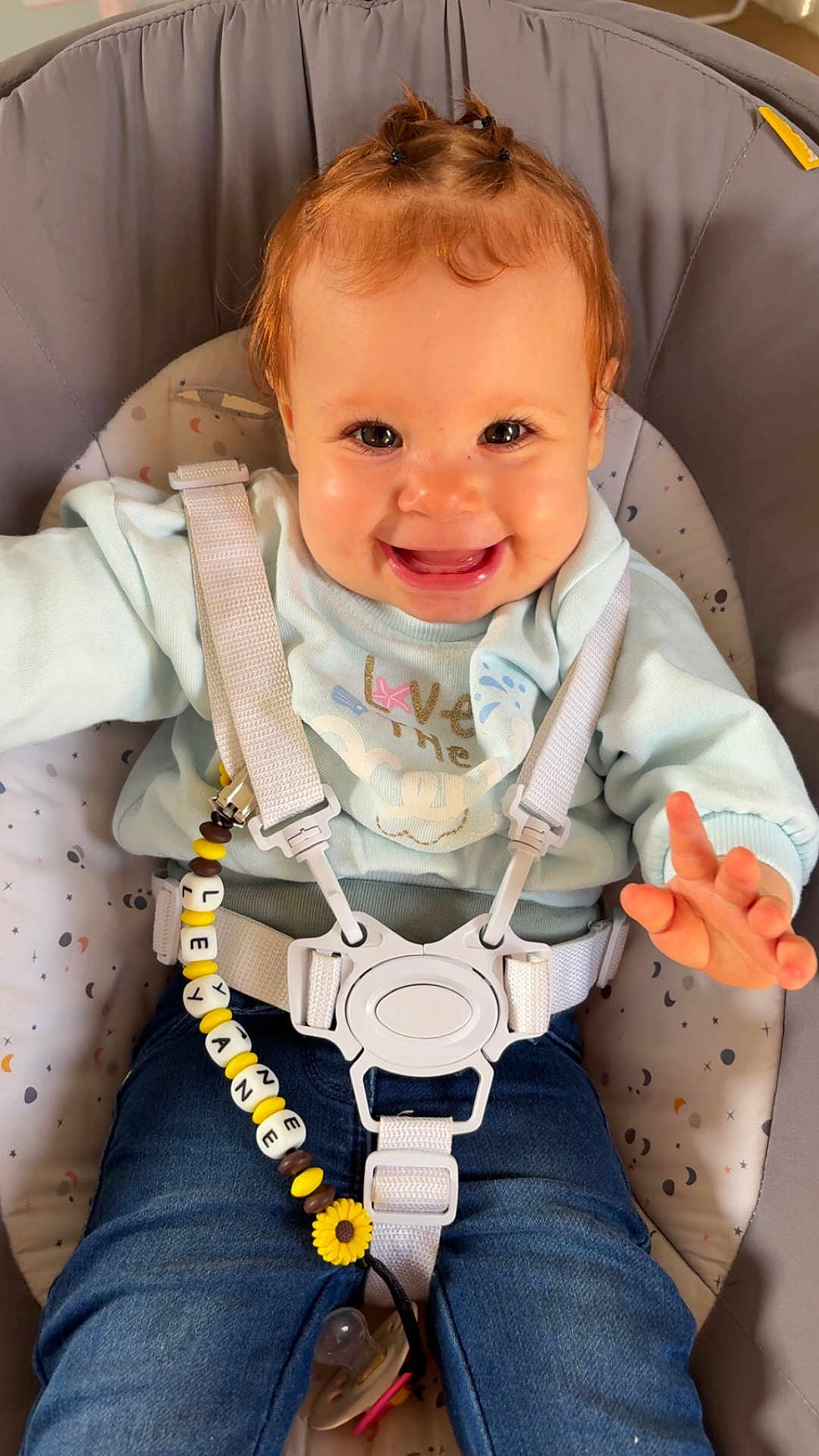 Leyane a rejoint le concours — aidez-le/la à gagner de superbes lots ! baby, child, smiling, happy, face, hair, pony_tail, clothing, sweater, jeans, baby_seat, safety_harness, pacifier, pacifier_clip, indoor, cute, comfort, infant, person, seated