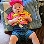 baby, infant, headband, pink, yellow_shirt, tie_dye, denim_shorts, couch, blanket, indoor, cute, expression, person, child, sitting, clothing, footwear_free, skin, relaxed, home