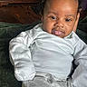 Jaceon is registered to the contest to win money with this photo: baby, child, infant, portrait, smiling, tongue_out, curly_hair, white_outfit, long_sleeves, gray_pants, blanket, cozy, indoor, bedroom, wooden_furniture, home, sitting, closeup, happy, casual_photo