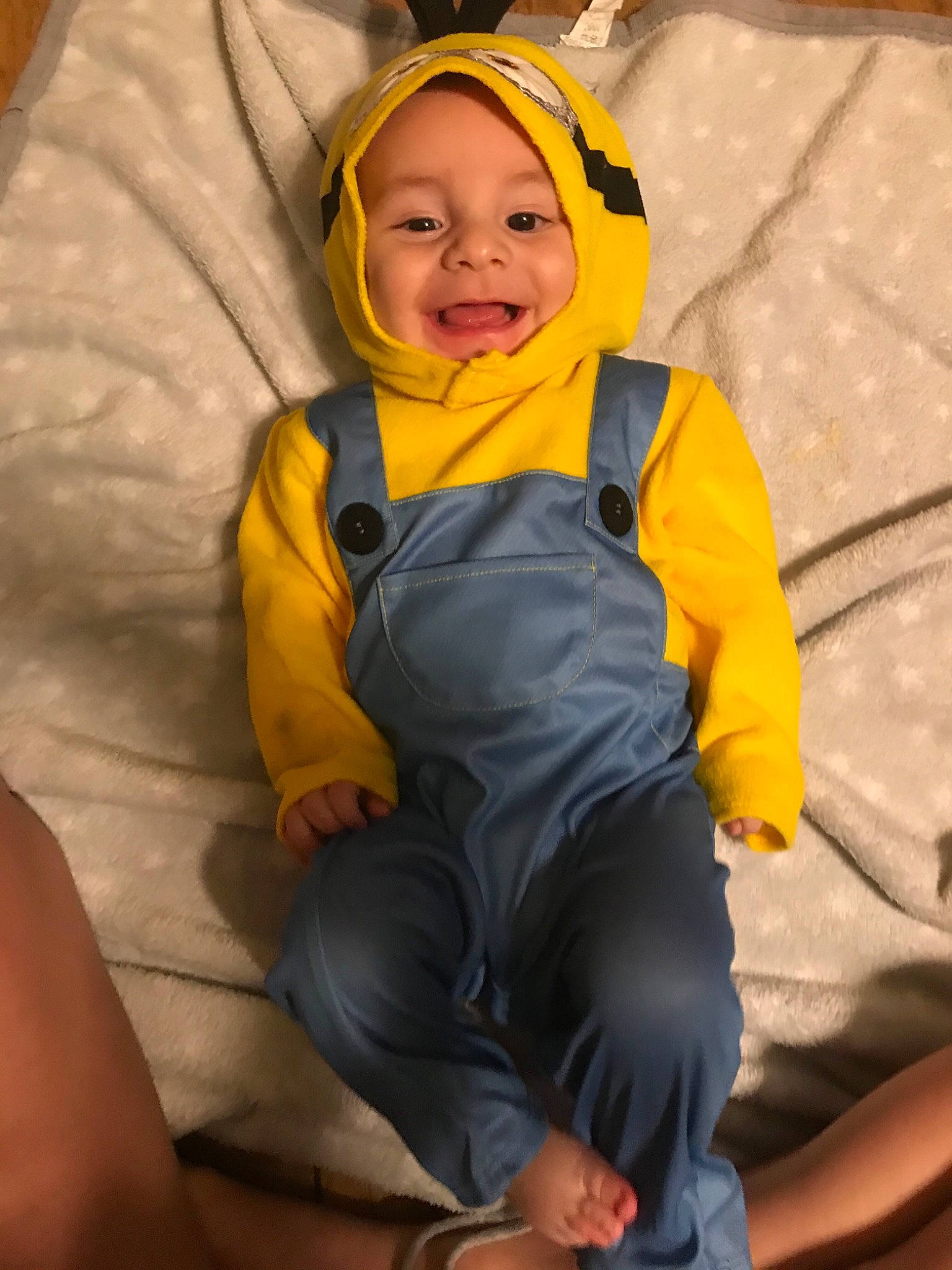 Joziah is registered to the contest to win money with this photo: baby, baby_laughing, baby_products, baby_toddler_clothing, barefoot, child, comfort, costume_accessory, foot, headwear, hood, lap, laugh, overall, person, thigh, toddler, toe, winter