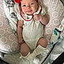 baby, infant, smiling, red_bow, headband, white_outfit, blanket, cushion, soft_toys, lying_down, indoor, cute, child, happy, person, sock, playpen, patterned, cozy, portrait