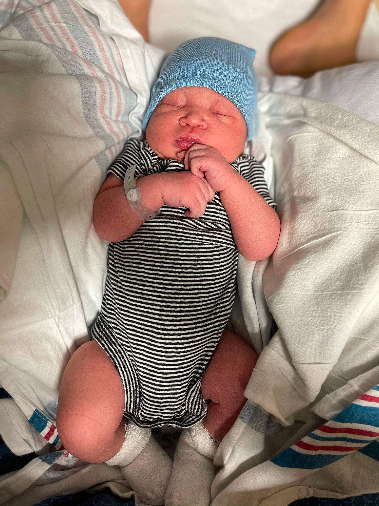 Julien is registered to the contest to win money with this photo: abdomen, baby, baby_toddler_clothing, child, comfort, finger, foot, headwear, human_body, human_leg, knee, lap, mouth, nail, person, skin, sock, stomach, textile, thigh