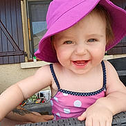 Octavia participe au concours pour gagner de l'argent avec cette photo : arm, casual, child, cute, daylight, face, hand, happy, outdoor, patio, person, pink_dress, polka_dot, purple_hat, shutters, skin, smiling, toddler, wicker_chair, window