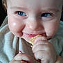 baby, bib, blue_eyes, cheeks, child, chubby_hands, close_up, cute, eating, face, fingers, food, hands, infant, mouth, nibble, portrait, skin, smile, young
