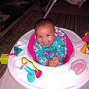 Nevaeh is registered to the contest to win money with this photo: baby, smiling, baby_walker, toy, indoor, carpet, child, infant, happy, clothing, face, person, furniture, playtime, colorful, seat, cute, small, joyful, home
