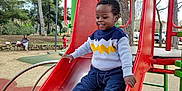 Kayden participe au concours pour gagner de l'argent avec cette photo : boots, casual_clothing, child, climbing_structure, daytime, fun, happy, leisure, nature, outdoor, park, person, play, playground, recreation, slide, smiling, sweater, toddler, trees
