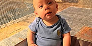 Leo is registered to the contest to win money with this photo: baby, infant, child, blue_onesie, playpen, mesh, blanket, sitting, indoors, curious, cute, chubby, hands, feet, face, wide_eyes, soft_lighting, comfortable, looking_at_camera, cozy