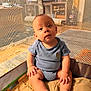 baby, infant, child, blue_onesie, playpen, mesh, blanket, sitting, indoors, curious, cute, chubby, hands, feet, face, wide_eyes, soft_lighting, comfortable, looking_at_camera, cozy