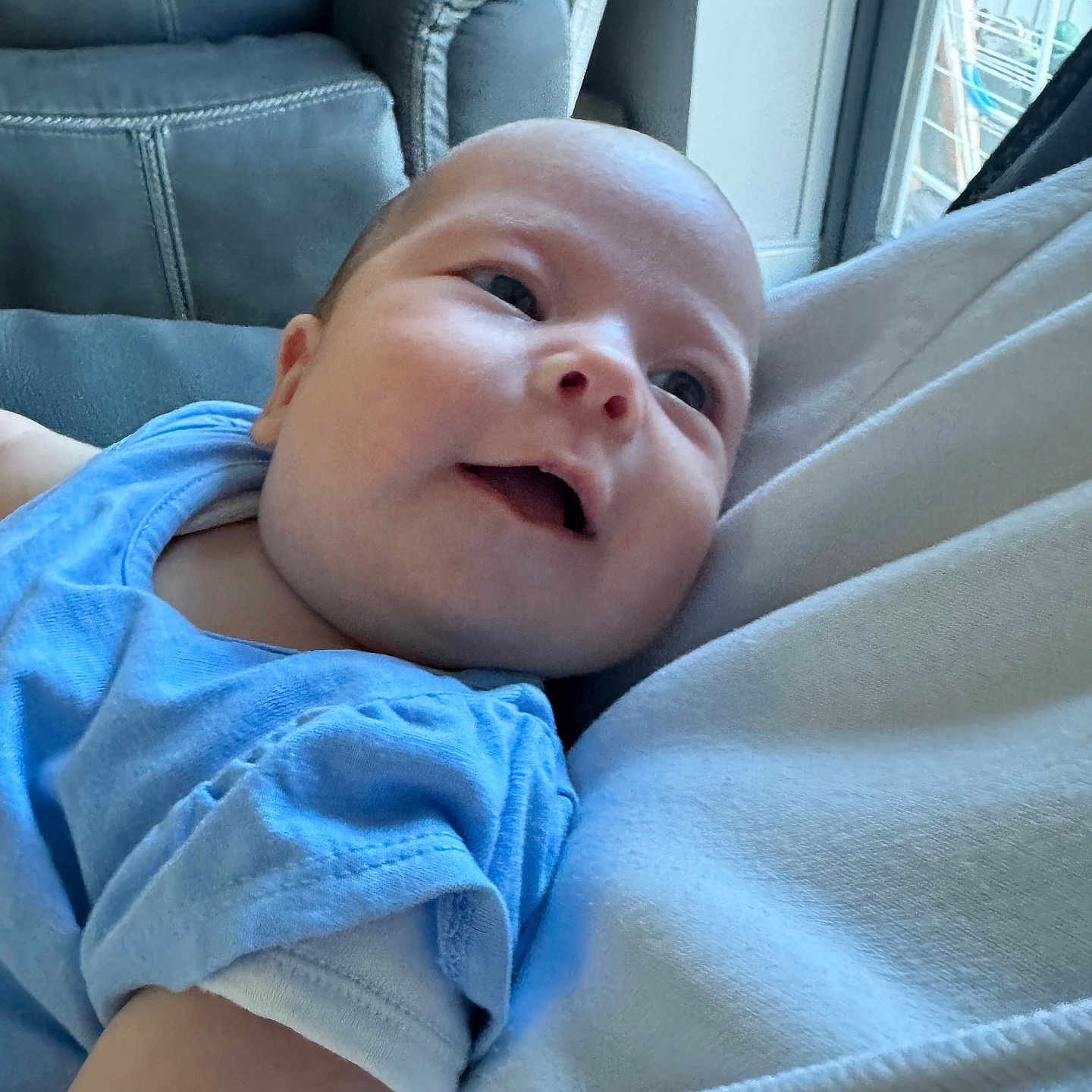 Poppy is registered to the contest to win money with this photo: baby, blue_clothing, child, couch, cozy, face, happy, head, home, indoors, infant, person, portrait, relaxed, skin, sleeve, smile, soft_light, upclose, young