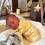 Clover is registered to the contest to win money with this photo: baby, newborn, onesie, yellow_clothing, plush_toy, baby_toy, blanket, soft_toy, stuffed_animal, penguin_toy, star_toy, baby_play_area, infant, crawling, floor, home_interior, wood_floor, candle, baby_activity_gym, cute
