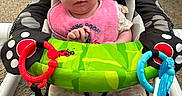 Kaisyn joined the competition — help win amazing prizes! baby, infant, pink_bib, baby_seat, toys, colorful, indoor, carpet, curious, child, face, clothing, socks, playtime, seat, person, living_room, cute, young_child, expression