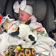 Kaisyn is registered to the contest to win money with this photo: baby, infant, car_seat, headband, bow, blanket, stuffed_toy, plush, sleeping, child, accessory, soft_toy, graco, cozy, cute, floral_pattern, sunflower, toy, comfort, peaceful