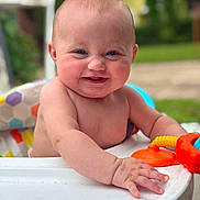 Nariah is registered to the contest to win money with this photo: baby, child, smiling, outdoor, toy, table, colorful, seat, skin, hand, face, cheeks, happy, playful, infant, nature, greenery, sunlight, portrait, closeup