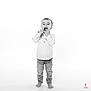 toddler, child, barefoot, standing, jeans, shirt, black_and_white, playful, funny_face, studio, portrait, isolated, young_child, expression, full_body, casual_clothing, smiling, candid, white_background, cute
