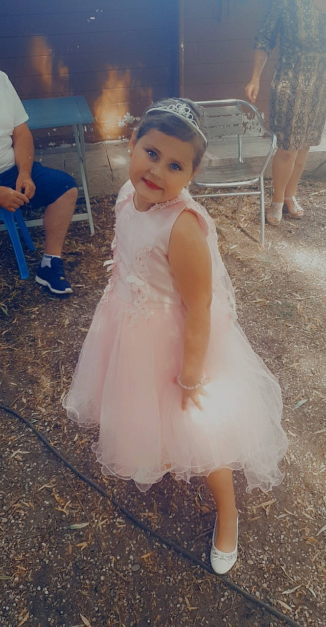 Zeina participe au concours pour gagner de l'argent avec cette photo : bridal_clothing, bridal_party_dress, dress, embellishment, flash_photography, flooring, fun, hairstyle, happy, headgear, iris, joy, leg, person, photograph, shoe, shorts, smile, standing, toddler