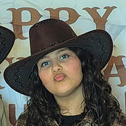 Zeina participe au concours pour gagner de l'argent avec cette photo : child, cowboy_hat, curly_hair, blue_eyes, plaid_shirt, portrait, face, person, puckered_lips, indoor, background_letters, casual_clothing, young_person, headwear, long_hair, fashion, smile, fun_expression, closeup, human