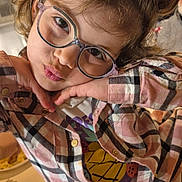 Néhémie participe au concours pour gagner de l'argent avec cette photo : child, glasses, plaid_shirt, pose, indoor, cute, young, face, smile, hair, fashion, person, portrait, playful, casual_clothing, tshirt, buttoned_shirt, expression, fun, happy