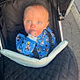 Arlo is registered to the contest to win money with this photo: baby, child, stroller, blue_onesie, cartoon_characters, thumb_sucking, outdoor, close_up, face, infant, cute, black_stroller, fabric, seatbelt, person, portrait, daylight, pavement, curious, baby_clothing