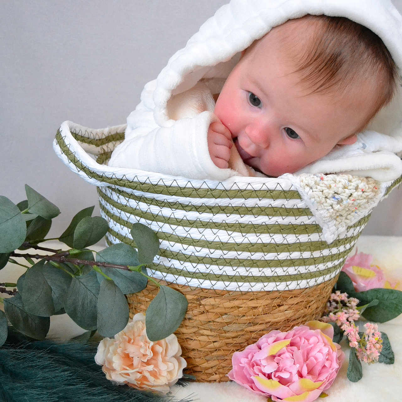 Olivia is registered to the contest to win money with this photo: baby, basket, blanket, bonnet, clothing, face, flower, flowerarrangement, flowerbouquet, hat, head, hood, leaf, newborn, person, petal, photography, plant, portrait, rose