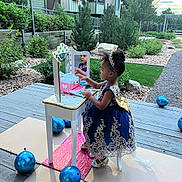 Lovely is registered to the contest to win money with this photo: balloons, blue, child, dress, garden, girl, gold, headband, mirror, outdoor, plants, play, portrait, reflection, rocks, shoes, sidewalk, toy, tree, vanity_table