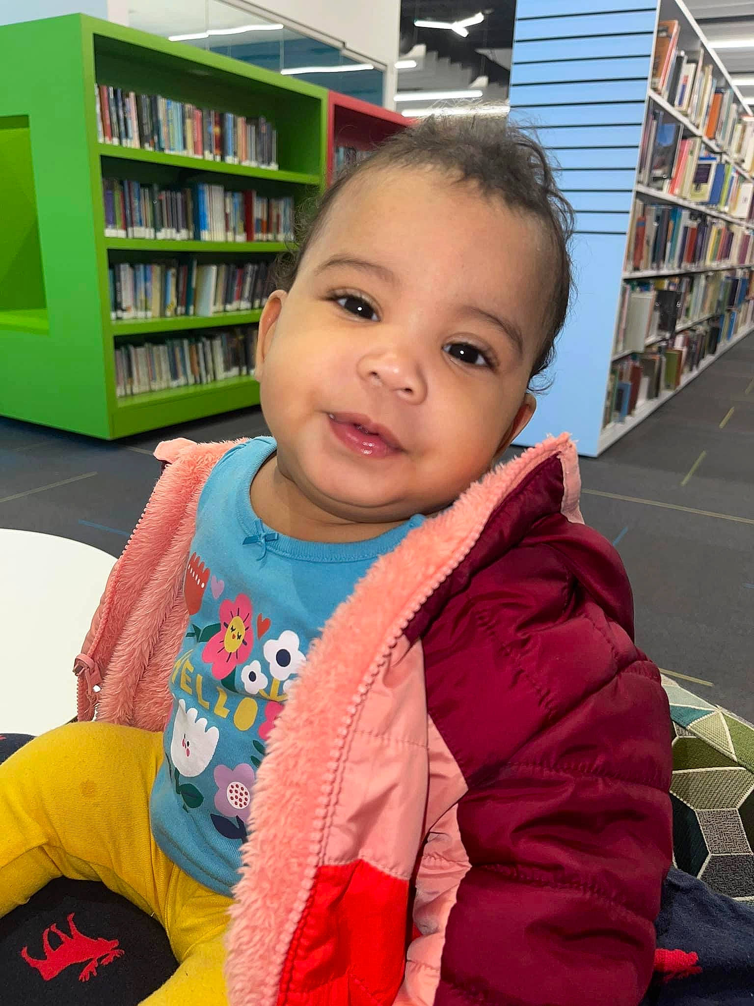 Kinsley joined the competition — help win amazing prizes! baby_toddler_clothing, beauty, bookcase, child, facial_expression, fun, happy, leisure, person, product, publication, retail, shelf, shelving, sitting, skin, sleeve, smile, standing, toddler