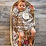 baby, infant, child, basket, floral_outfit, headband, boots, blanket, wooden_floor, plaque, ten_months, cute, lying_down, indoors, cozy, patterned_clothing, footwear, baby_boy, baby_girl, portrait
