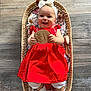baby, infant, girl, red_dress, headband, bow, basket, wooden_floor, wooden_plaque, smile, happy, toy, brush, white_socks, floral_fabric, lying_down, cute, child, indoors, portrait