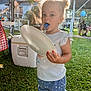 Isabella is registered to the contest to win money with this photo: toddler, child, outdoor, grass, plate, blue_tongue, messy_face, summer, tent, people, casual_clothing, shorts, shirt, sunlight, daytime, family_gathering, cooler, picnic, nature, playful