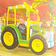 Ayden a rejoint le concours — aidez-le/la à gagner de superbes lots ! amusement_ride, carnival, child, clothing, face, fun, green, happy, indoor, jeans, light, person, play, seat, smiling, toy, tractor, vehicle, wheel, yellow