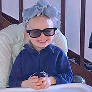 Ayden a rejoint le concours — aidez-le/la à gagner de superbes lots ! child, toddler, high_chair, sunglasses, smile, headwrap, indoor, person, happy, hands, clothing, face, baby, seat, wooden, railing, cute, fashion, casual, portrait