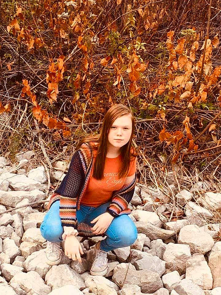 Olivia is registered to the contest to win money with this photo: autumn, beauty, branch, fawn, leaf, long_hair, orange, people_in_nature, person, photo_shoot, photograph, photography, plant, portrait_photography, rock, sitting, smile, tree