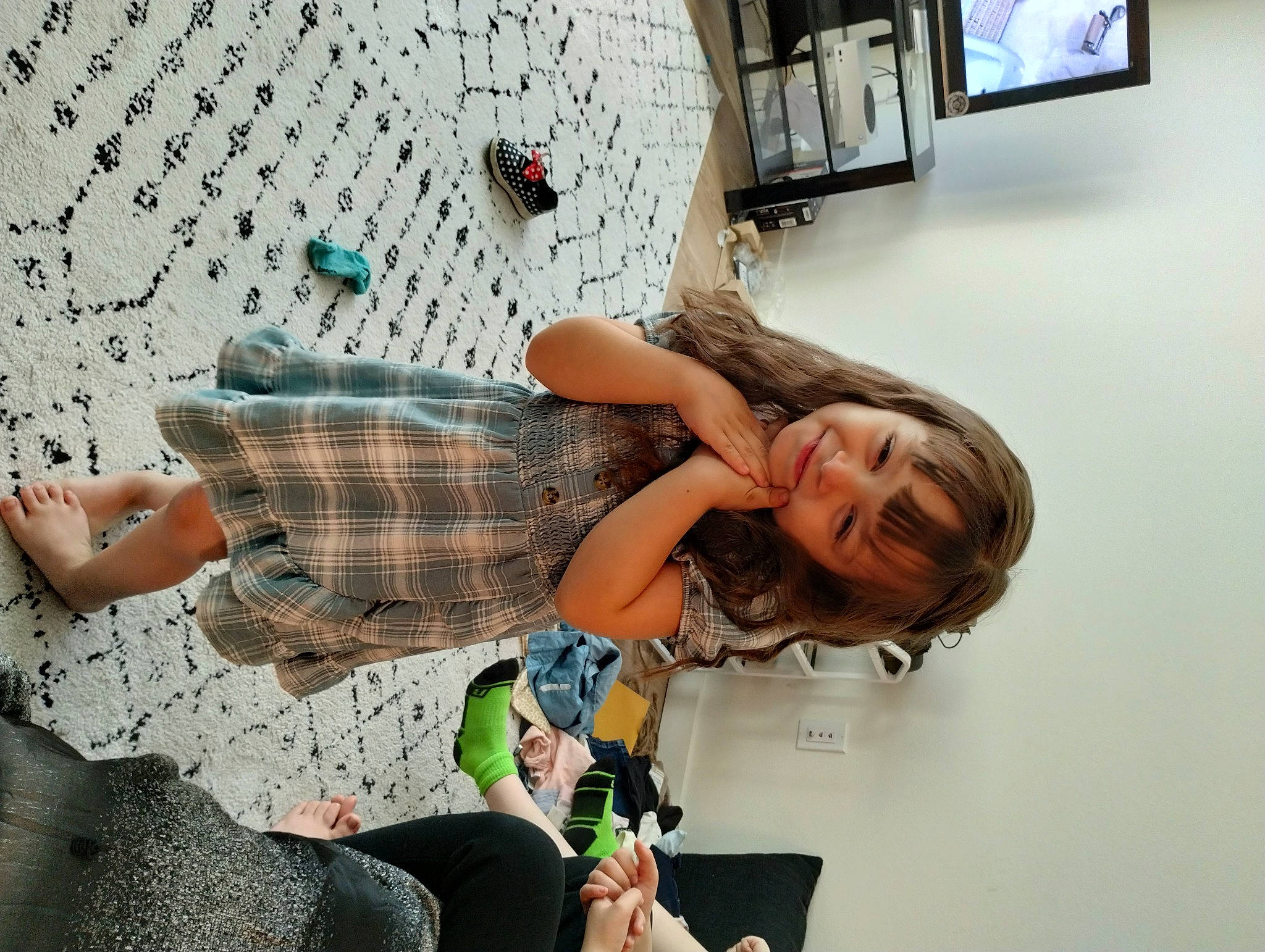 Deja is registered to the contest to win money with this photo: child, comfort, fun, happy, human_leg, joy, leisure, pattern, person, photography, picture_frame, plaid, play, room, sitting, smile, television, television_set, thigh, vacation