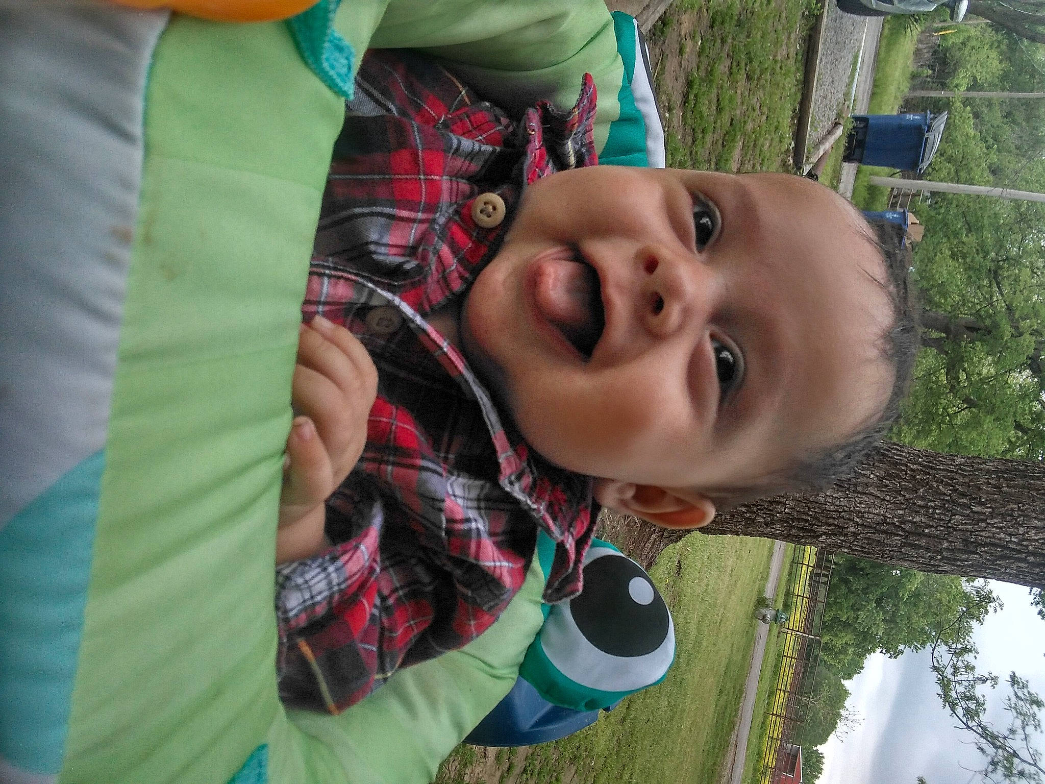 Luciàno is registered to the contest to win money with this photo: baby, child, fun, grass, green, happy, leisure, mouth, nose, pattern, people_in_nature, person, plaid, plant, recreation, sky, smile, tartan, toddler, tree