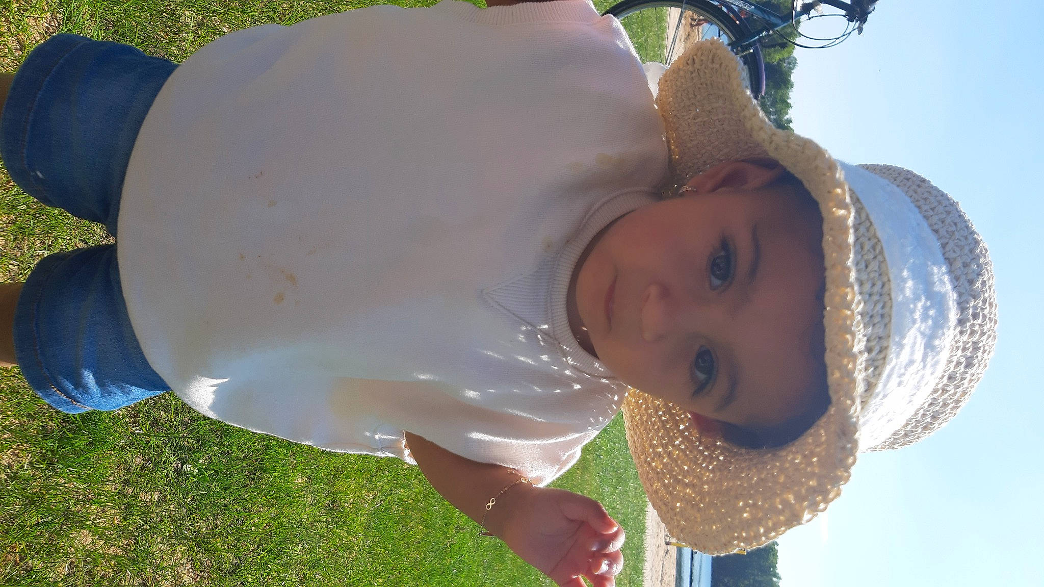 Myriam participe au concours pour gagner de l'argent avec cette photo : baby, cap, child, fashion_accessory, fun, grass, green, happy, hat, head, headgear, headwear, leisure, people_in_nature, person, portrait_photography, recreation, sky, sun_hat, toddler