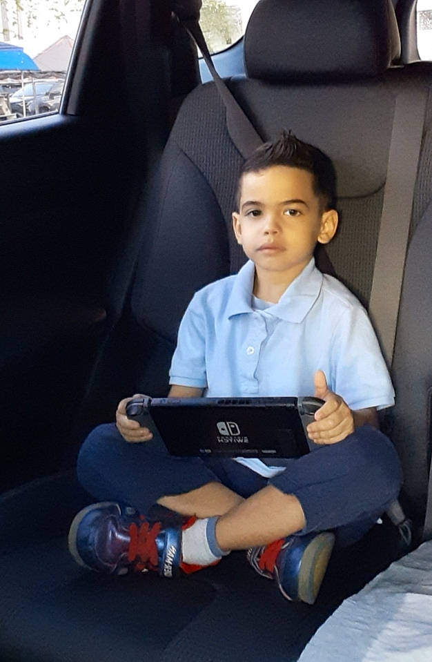 Jorge is registered to the contest to win money with this photo: auto_part, car, car_seat, child, driving, family_car, head_restraint, leg, passenger, person, reading, seat_belt, sitting, toddler, vehicle