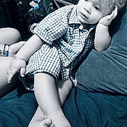 Manoah a rejoint le concours — aidez-le/la à gagner de superbes lots ! barefoot, casual, checkered_shirt, child, couch, cozy, curly_hair, cute, expression, home, indoor, person, pillow, portrait, relaxed, resting, sitting, skin, toddler, young_child